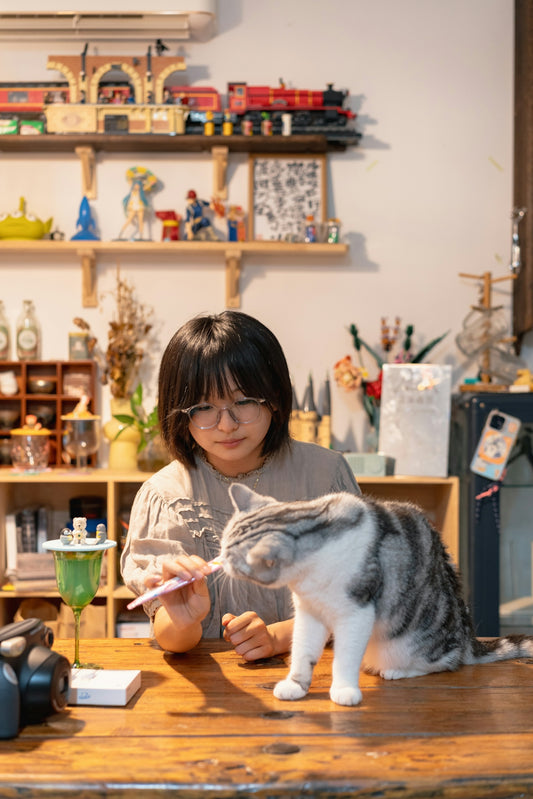A woman sitting at a table with a cat