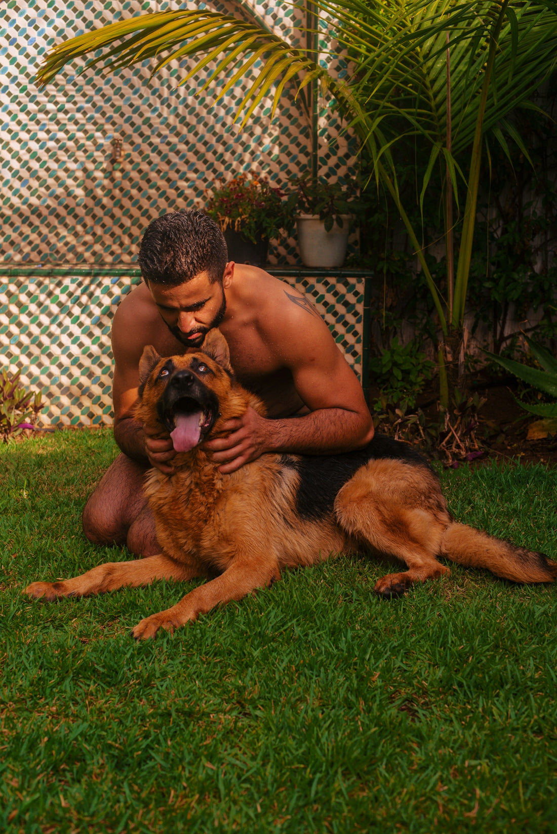 a person lying on the grass with a dog