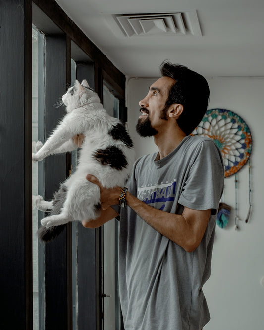 a man holding a cat up to his face