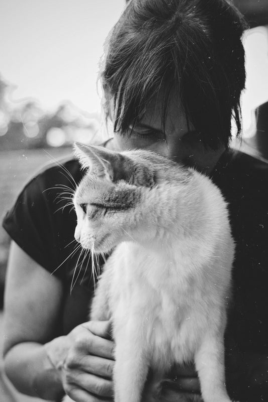 A black and white photo of a woman holding a cat