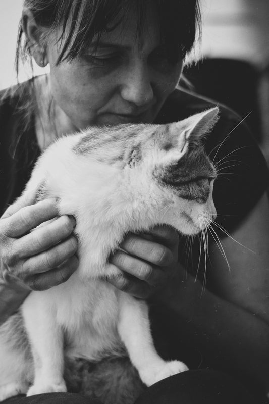 A black and white photo of a woman holding a cat